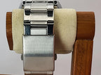 Close-up of a stainless steel Aokulasic Open Heart Automatic watch band clasp mounted on a cream-colored display stand with a wooden frame.