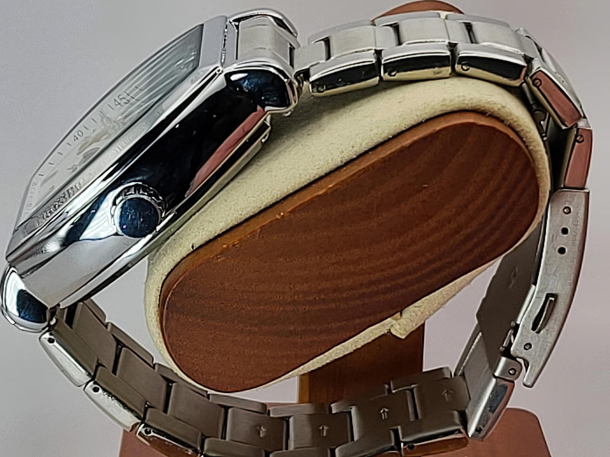 A silver stainless steel Aokulasic Open Heart Automatic watch with a multi-link bracelet, shown from the side and back resting on a brown wooden display stand with a cream cushion.