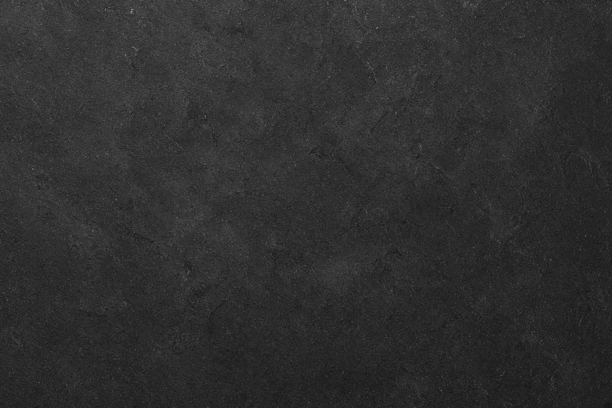 A dark charcoal gray textured surface with a fine, mottled pattern resembling concrete, stone, or dark slate.
