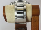 Close-up of a stainless steel Seiko Flightmaster watch band mounted on a wooden display stand with a beige velvet roll.