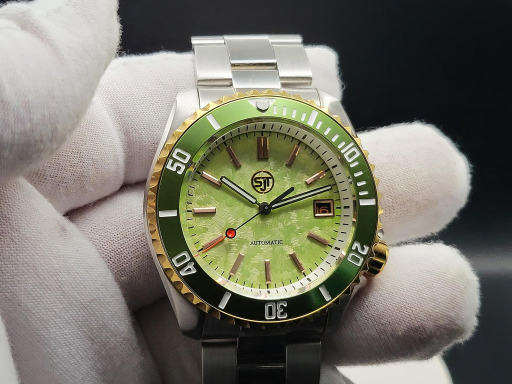 The Coconut SJT Original wristwatch with a green dial and green bezel, held by white-gloved hands against a dark background.