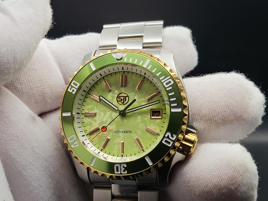 The Coconut SJT Original wristwatch with a green dial and green bezel, held by white-gloved hands against a dark background.