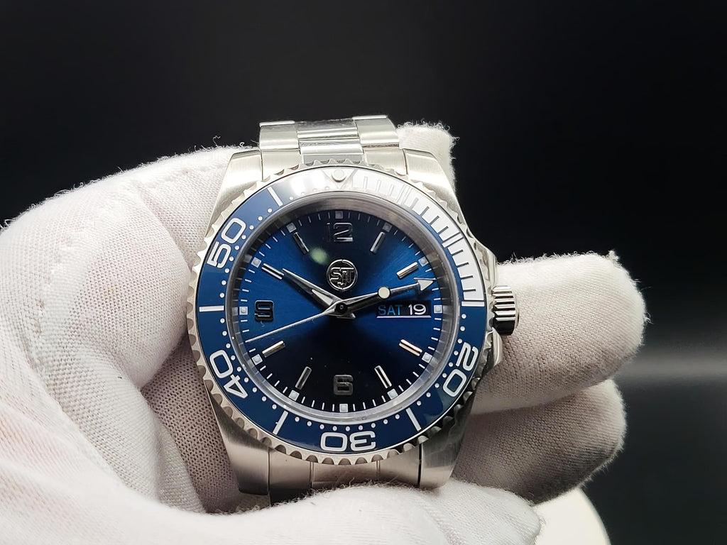 The Memo SJT Original wristwatch with a blue dial and blue bezel, held in a white-gloved hand against a dark background.