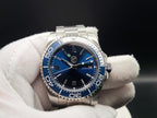 The Memo SJT Original wristwatch with a blue dial and blue bezel, held in a white-gloved hand against a dark background.