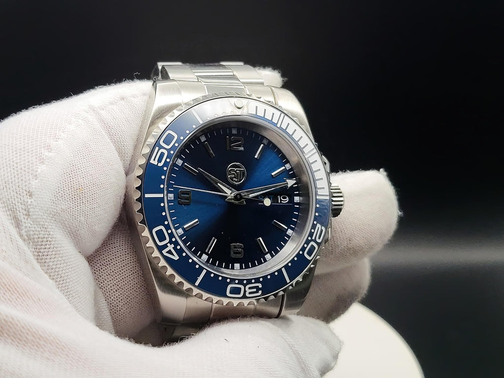 The Memo SJT Original wristwatch with a blue dial and blue bezel, held in a white-gloved hand against a dark background.