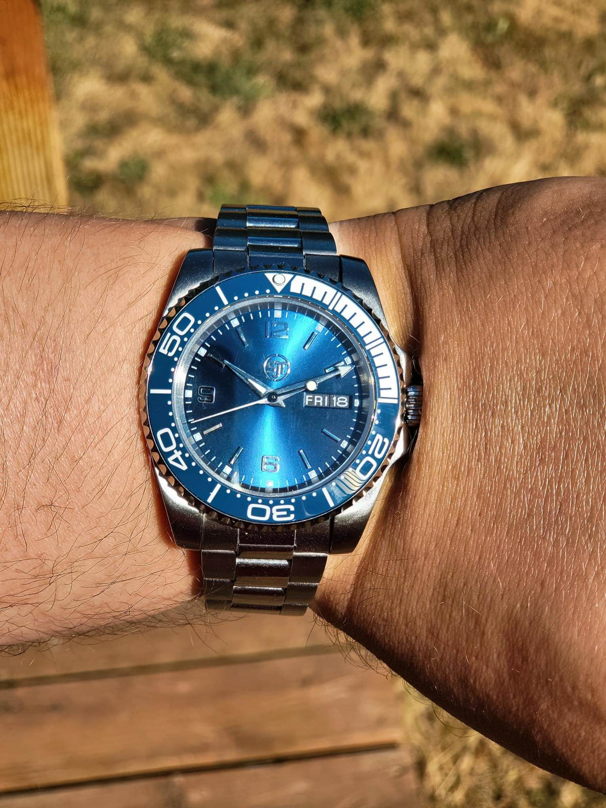 The Memo SJT Original wristwatch with a blue dial and blue bezel, worn on a person's wrist outdoors.
